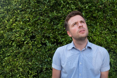 successful young caucasian man looking to the side suspiciouslyの写真素材