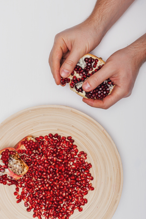 hand holding pomegranate isolated on white backgroundの写真素材