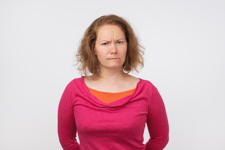 Young funny european woman is offended. She is looking with disbelief at cameraの写真素材