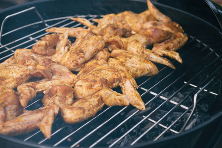Spicy cooking chicken wings grilling on a summer barbecueの写真素材