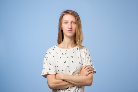 Smiling european woman with crossed arms looking confident ahead standing on blue backgroundの写真素材