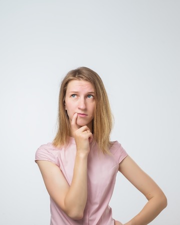 young pensive caucasian woman over white background