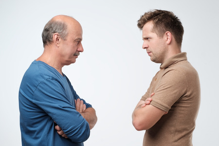 Mature father and son looking on each other face to face. They quarreled. To make claims and...