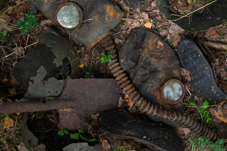 Traces of Second World War in Russia. Old gas mask, boots and rusty details on ground. Top viewの写真素材
