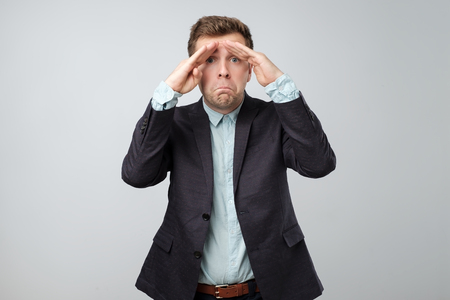 Stressed frustrated man looks displeased making depressed face.の写真素材