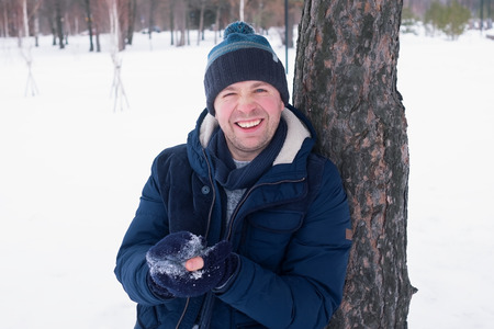 Outdoor portrait of smiling handsome man in coat and scurf. Casual winter fashionの写真素材