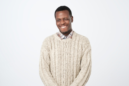 Dark skinned man blinks eye and has appealing smile, flirts with beautiful woman.の写真素材
