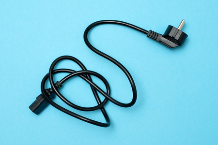 Black power cable line for computer on blue background.の写真素材