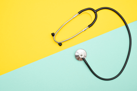 Medical phonendoscope or stethoscope isolated on yellow and blue background with copyspace.の写真素材