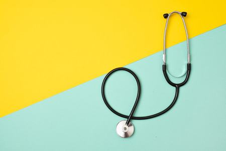 Medical phonendoscope or stethoscope isolated on yellow and blue background with copyspace.の写真素材