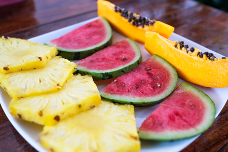 plate containing pieces of fruit, papaya, watermelon and pineapple. Ready to have asian breakfast or lunchの写真素材