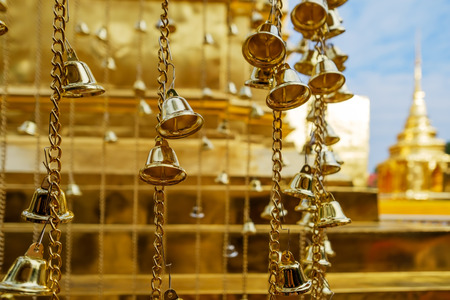 Many golden buddhist bells in sunlight in Thailandの写真素材