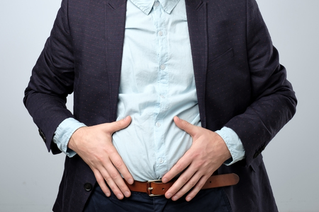 Stomach pain. man in suit holding his stomach