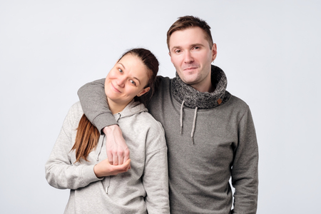 Young european couple standing against white gray backgroundの写真素材