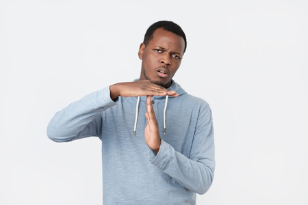 Young african man showing time out hands gesture isolated.の写真素材