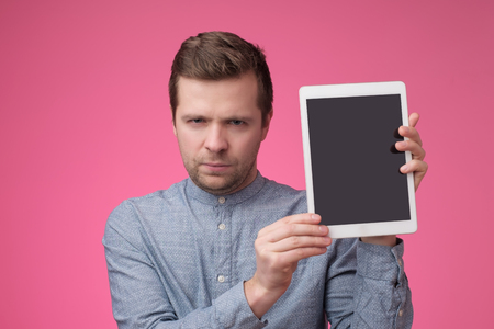 Man show with the blank screen of tablet and finger point upの写真素材