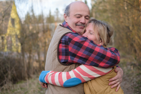 Senior caucasian couple hugging each other walking outdoor at autumn. True love through all life.の写真素材