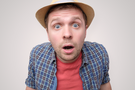 Man in summer hat opening mouth in shockの写真素材
