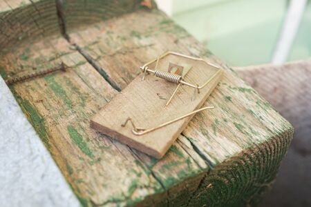 Empty broken wooden home mousetrap. Closeup of an unloaded mouse trap.