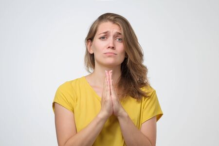 Girl, hope friends make favour. Young woman standing press palms together begging pray for help....