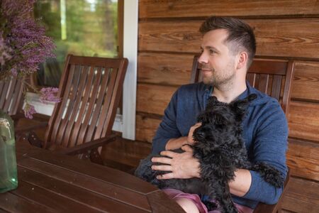 handsome caucasain man with dog sitting outdoor