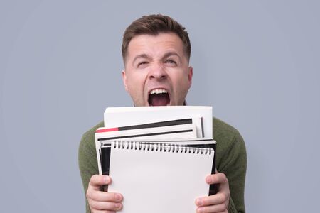 Irritated angry tired college student with a books tired to studyの写真素材