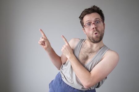 Careless carefree man in huge glasses point finger aside up recommend cheap offerの写真素材