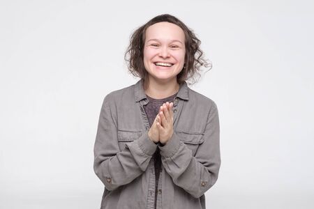 Caucasian pretty woman laughing on funny joke having excellent mood. Studio shotの写真素材
