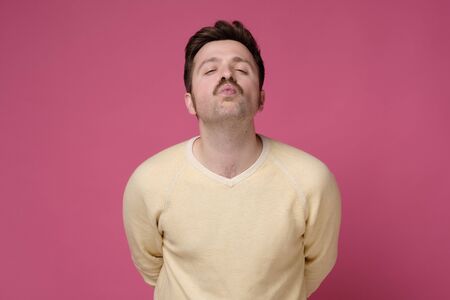 Young caucasian man with funny mustache rounds lips, waiting for kiss. Romantic relationships....