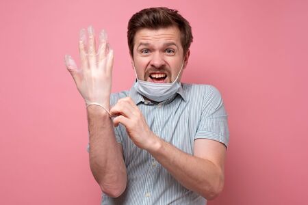 Frightened man in protective hygienic mask afraiding of coronavirus epidemic, infection, respiratory...