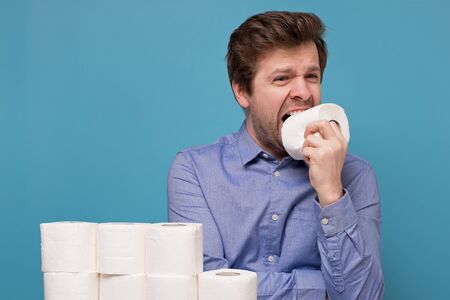 Concept of Funny caucasian young man eats a toilet paper.