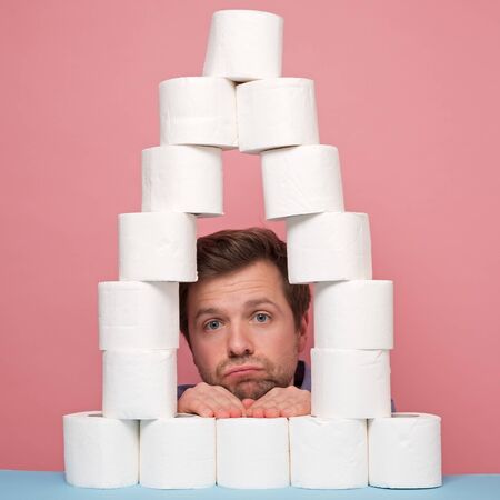 Sad, depressed man during the coronavirus quarantine staying at home made from toilet paper....
