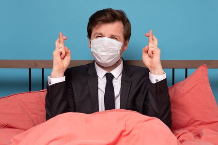 Young caucasian man in suit making a wish sitting at home on quarantine. I wish coronavirus pandemic...