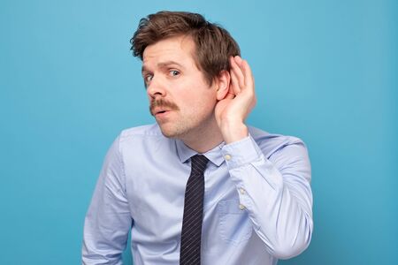 Handsome guy trying secretly listen on a conversation, privacy violation,の写真素材