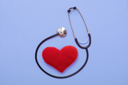 heart with a stethoscope, isolated on violete backgroundの写真素材