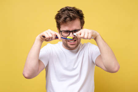 young man puts toothpaste on a toothbrush.の写真素材