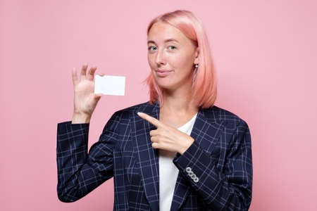 Happy caucasian woman with dyed hair showing blank credit card