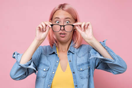 Surprised woman in disbelief taking off or on glasses.の写真素材