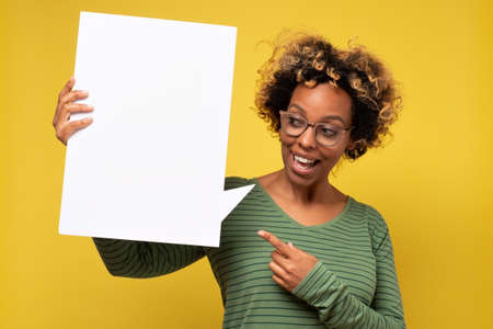 Happy african american young woman holding blank speech bubbleの写真素材