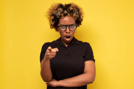 It is your fault. Disappointed angry young african woman frowning pointing index finger at camera,の写真素材