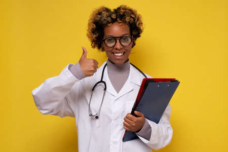 African woman doctor smiling at camera showing thumb upの写真素材