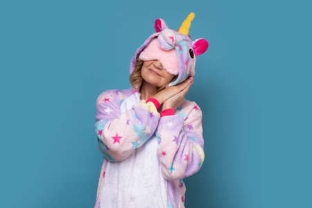 Mature woman in warmfunny pajamas with sleeping mask on her eyes sleeping.の写真素材