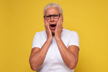 Anxious shocked elderly woman having frustrated stressed expressionの写真素材