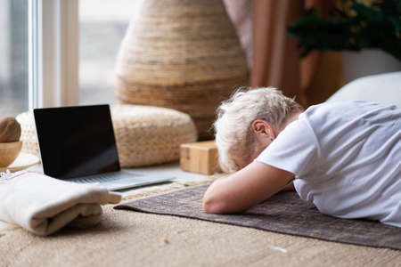 woman relaxes in yoga asana Makarasana or crocodile pose during online lessonの写真素材