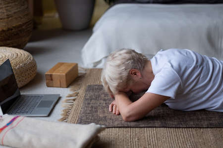senior woman relaxes in yoga asana Makarasana or crocodile poseの写真素材