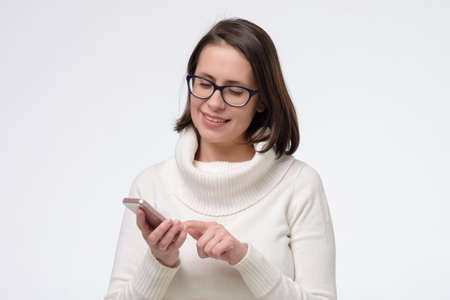 mature woman text messaging and surfing the net with her smart phoneの写真素材