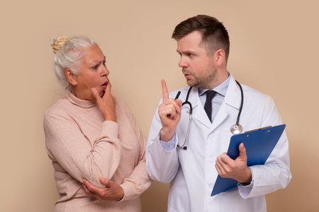 Male caucasian doctor talking with his senior patient