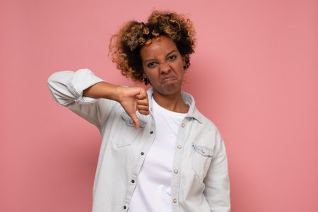 African young woman doing a thumbs down signal with her hand.