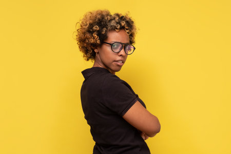 Serious african young woman turning back looking at camera.の写真素材