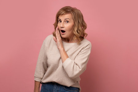 Senior woman with hand on mouth telling secret rumor